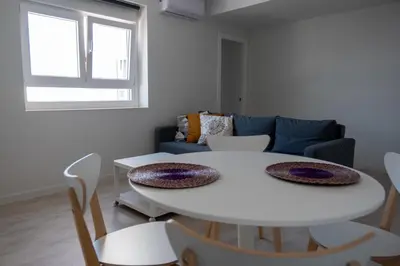a living room with a white table and a couch at El mirador de Ancha in Cádiz