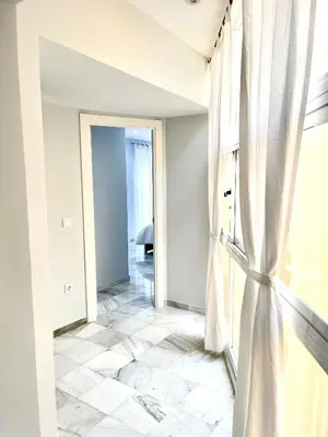 an empty hallway with a window and a tiled floor at Cartujano City Center Apartment in Jerez de la Frontera