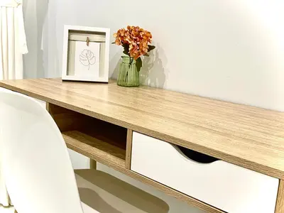 a table with a vase of flowers and a picture at Cartujano City Center Apartment in Jerez de la Frontera