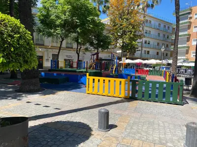 a playground in a park with a colorful fence at Cartujano City Center Apartment in Jerez de la Frontera