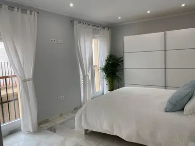 a bedroom with a large bed and a large window at Cartujano City Center Apartment in Jerez de la Frontera