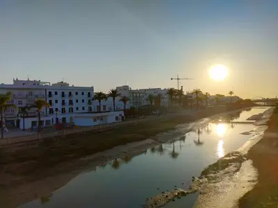 a view of a river with the sun setting at Apartamento La Paraíta in Chiclana de la Frontera