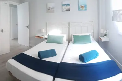 a large bed with two blue pillows on it at La Isla Centro II in San Fernando