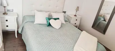 a bedroom with a bed with a heart pillow on it at Piso 100 metros del Centro del Pueblo 6 kilómetros de la PLAYA La BARROSa in Chiclana de la Frontera
