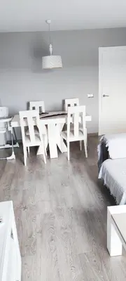 a white room with a dining table and chairs at Piso 100 metros del Centro del Pueblo 6 kilómetros de la PLAYA La BARROSa in Chiclana de la Frontera