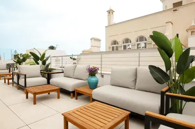 a row of couches and tables on a roof at Goodnight Cádiz Apartments in Cádiz
