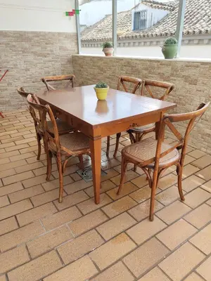 a wooden table and chairs on a patio at Apartamento Nao Victoria in Sanlúcar de Barrameda