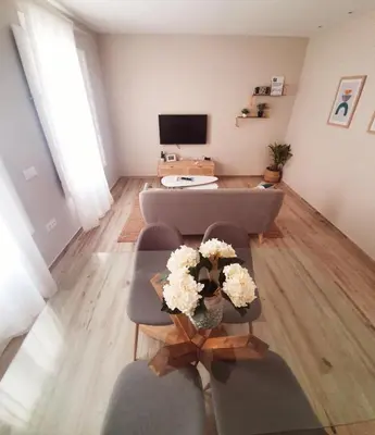 a living room with a couch and a table with flowers at Cádiz desde el balcón in Cádiz