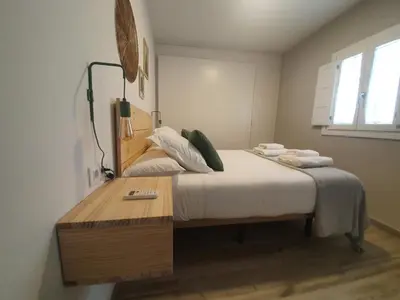 a bedroom with a bed and a wooden table at Cádiz desde el balcón in Cádiz