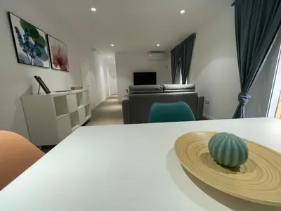 a living room with a white table and a couch at Apartamento Nebro Estrella, En el Corazón de Cádiz in Cádiz