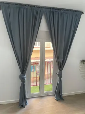 a window with blue curtains in a room at Apartamento Nebro Estrella, En el Corazón de Cádiz in Cádiz