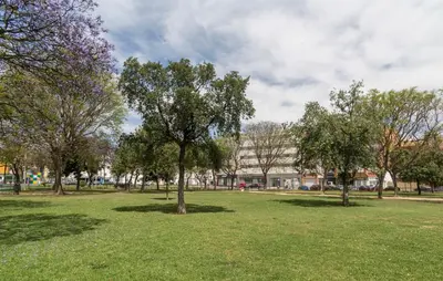 a park with trees and a building in the background at Azvalia - Edificio Parque in El Puerto de Santa María