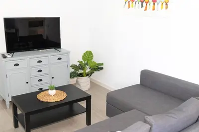a living room with a couch and a tv at Villa ANDROMEDA in Chiclana de la Frontera