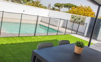 a patio with a table and a swimming pool at Villa ANDROMEDA in Chiclana de la Frontera