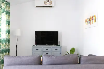 a living room with a couch and a flat screen tv at Villa ANDROMEDA in Chiclana de la Frontera