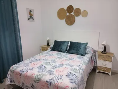 a bedroom with a bed and two tables with lamps at Villa ANDROMEDA in Chiclana de la Frontera