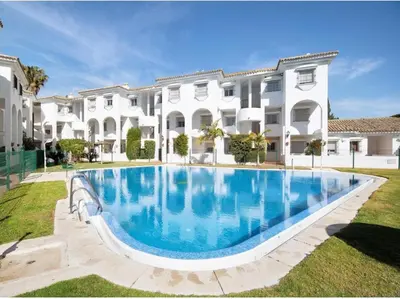 a large swimming pool in front of a building at Apartamento vacacional máximo 4 personas in Novo Sancti Petri