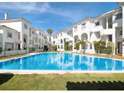 a large swimming pool in front of some buildings at Apartamento vacacional máximo 4 personas in Novo Sancti Petri