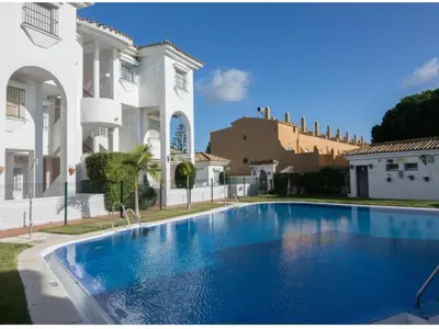 a large blue swimming pool in front of a building at Apartamento vacacional máximo 4 personas in Novo Sancti Petri