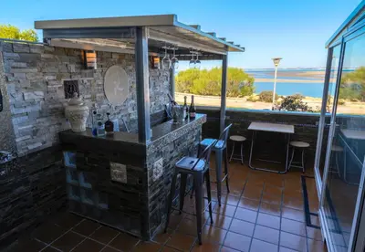 a bar on a balcony with a view of the ocean at Oceanum Visum Spa Deluxe in El Trocadero