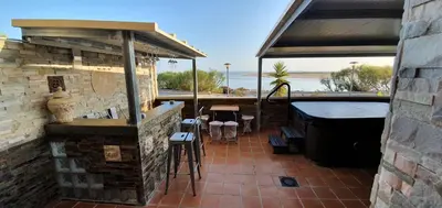 a patio with a bar and a bath tub at Oceanum Visum Spa Deluxe in El Trocadero