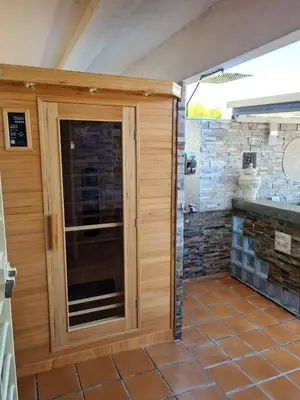 a pivot door in a patio with a stone wall at Oceanum Visum Spa Deluxe in El Trocadero