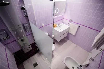 a purple bathroom with a sink and a toilet at Oceanum Visum Spa Deluxe in El Trocadero