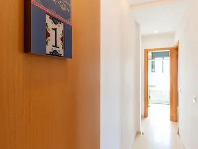 a hallway with orange walls and a clock on the wall at Apartamento LABORT Apartamento Boutique in Cádiz