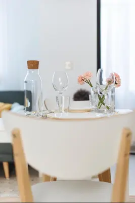 a white table with glasses and flowers on it at LyriosHomes Chipiona Beach in Chipiona