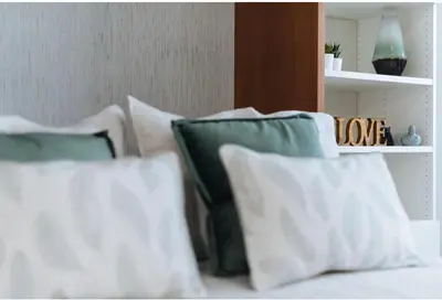 a group of pillows on a bed with a shelf at LyriosHomes Chipiona Beach in Chipiona