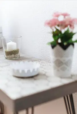 a table with a candle and a vase with pink flowers at LyriosHomes Chipiona Beach in Chipiona
