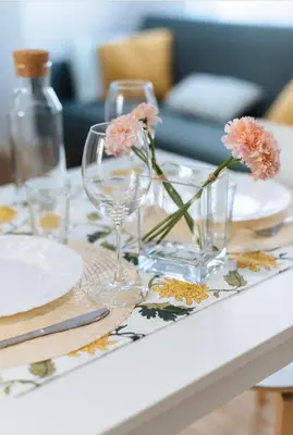 a table with two wine glasses and flowers on it at LyriosHomes Chipiona Beach in Chipiona