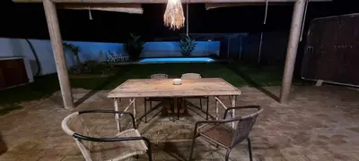 a wooden table and chairs on a patio at night at Las Casitas de la Barrosa con jardín y piscina in Chiclana de la Frontera