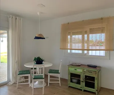 a kitchen with a table and chairs and a table and a table at Las Casitas de la Barrosa con jardín y piscina in Chiclana de la Frontera