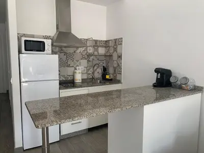 a kitchen with a white refrigerator and a counter top at HOLIDAY ALYMA in Sanlúcar de Barrameda