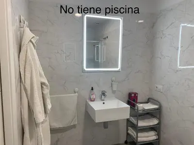 a bathroom with a white sink and a mirror at HOLIDAY ALYMA in Sanlúcar de Barrameda