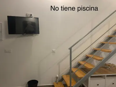 a flat screen tv on a wall next to a staircase at HOLIDAY ALYMA in Sanlúcar de Barrameda