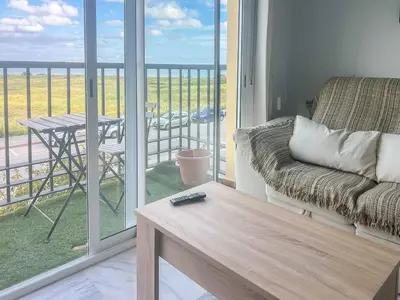 a living room with a couch and a balcony with a table at GuestReady - San Fernando Ronda Estero III in San Fernando