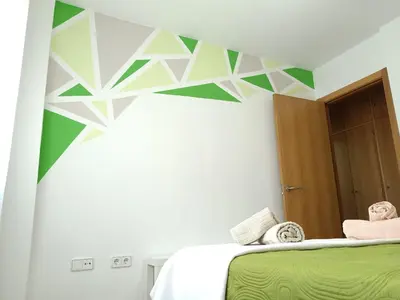 a bedroom with a green and white wall at Apartamentos Coralba - El Escondite de la Bahía in San Fernando