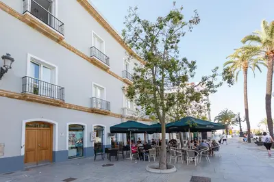 people sitting at tables under umbrellas outside a building at Atico-Solarium CITY Hall by Cadiz4Rentals in Cádiz