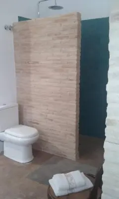 a bathroom with a toilet and a wall at el rinconcito in Sanlúcar de Barrameda