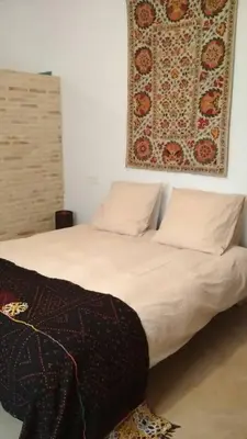 a bed with two pillows and a picture on the wall at el rinconcito in Sanlúcar de Barrameda