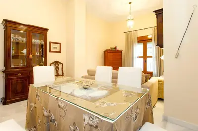 a living room with a table and white chairs at Casa Singular , parking gratis in Jerez de la Frontera