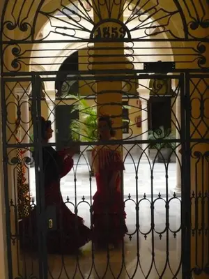 two women are standing behind a gate at Casa Singular , parking gratis in Jerez de la Frontera