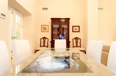 a dining room with a glass table and white chairs at Casa Singular , parking gratis in Jerez de la Frontera