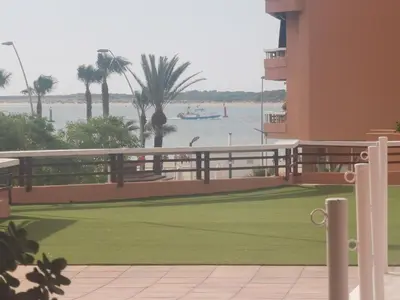 a balcony with a view of the water and a boat at Apartamentos Sanlúcar Beach 2 y 3 in Sanlúcar de Barrameda