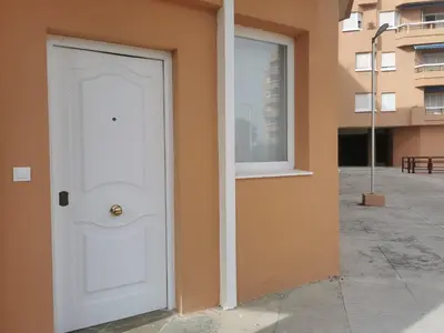 a white door on the side of a building at Apartamentos Sanlúcar Beach 2 y 3 in Sanlúcar de Barrameda