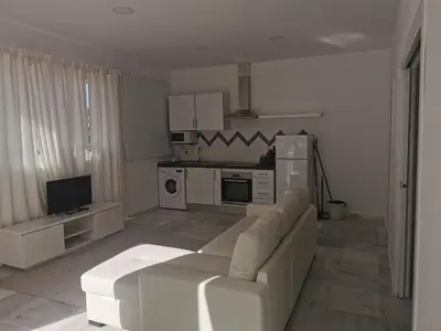 a living room with a couch and a kitchen at Apartamentos Sanlúcar Beach 2 y 3 in Sanlúcar de Barrameda
