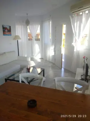 a living room with a white couch and chairs at Apartamentos Sanlúcar Beach 2 y 3 in Sanlúcar de Barrameda