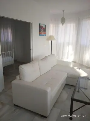 a white living room with a white couch and a table at Apartamentos Sanlúcar Beach 2 y 3 in Sanlúcar de Barrameda